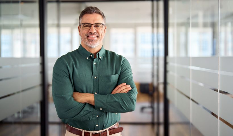 Smiling older bank manager or investor, happy middle aged business man boss leader, confident mid adult professional businessman executive standing in office hallway, mature entrepreneur portrait.